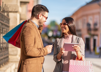 Happy couple carrying shopping bags and enjoying together