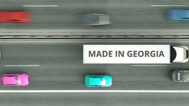 Trailer trucks with MADE IN GEORGIA text driving along the road. Georgian business related loopable 3D animation