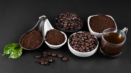 Fresh raw organic coffee beans with ground powder  on black.