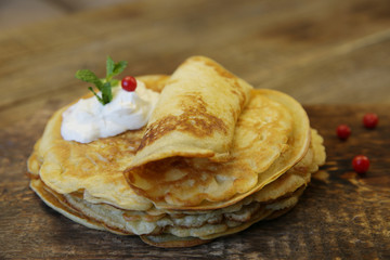 closeup tasty pancakes with sour cream on a wooden rustic background