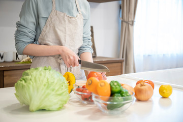 キッチンで調理をする若い女性の手元