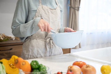 キッチンで調理をする若い女性の手元