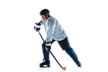 Fototapeta na wymiar Scoring. Young male hockey player with the stick on ice court and white background. Sportsman wearing equipment and helmet practicing. Concept of sport, healthy lifestyle, motion, movement, action.
