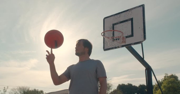 Portrait of male basketball player spinning the ball on finger.