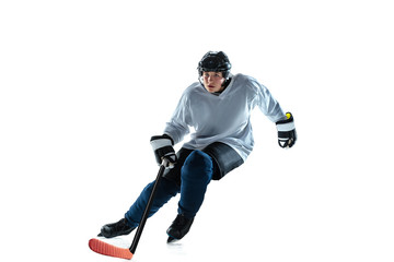 Fototapeta na wymiar Leader. Young male hockey player with the stick on ice court and white background. Sportsman wearing equipment and helmet practicing. Concept of sport, healthy lifestyle, motion, movement, action.