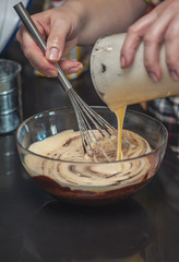 Dessert cream for lava cake cooking with hands in glass bowl