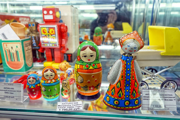 Clockwork doll, matryoshka. Showcase with old toys in a retro toy store.
