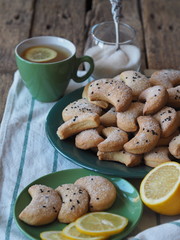 Homemade shortbread cookies sprinkled with sugar with black sesame seeds on a wooden rustic table. Tea party with cookies and lemon. Place for text. Photo for the holiday.