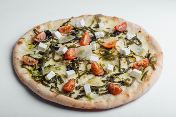 Pizza with tomatoes, feta, parmesan and kale on a white background