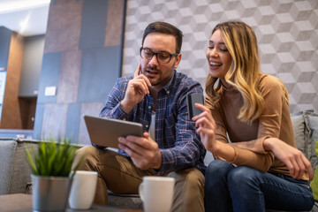 Smiling couple with tablet at home