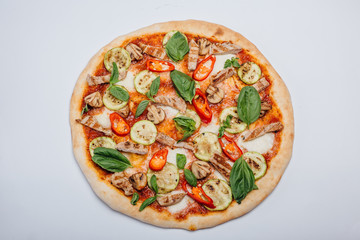 Pizza with slices of meat with basil and pepper. Italian pizza on a white background