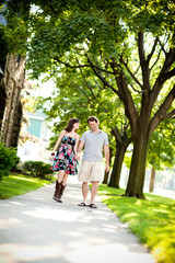 Fototapeta na wymiar Happy Young Couple Walking on Sidewalk in Neighborhood