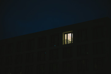 Beleuchtetes Bürofenster in dunkler Nacht