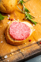 Bread with salami on the wooden background. Shallow depth of field.