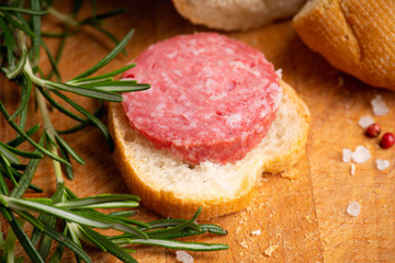 Bread with salami on the wooden background. Shallow depth of field.