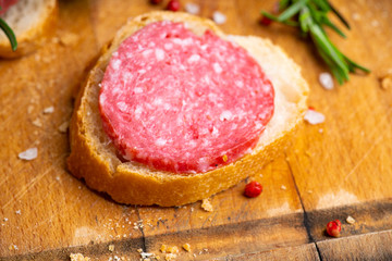 Bread with salami on the wooden background. Shallow depth of field.