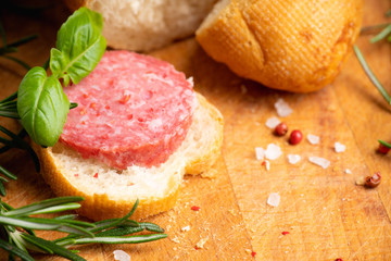 Bread with salami on the wooden background. Shallow depth of field.