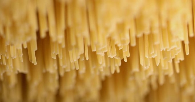 Suggestive macro closeup shot of raw italian pasta spaghetti noodles dried in a pasta factory. Soft focus on raw food.