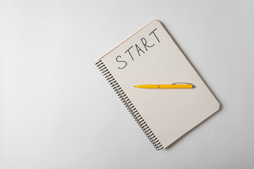 Start written on notebook over white background. Planning new business. Top view