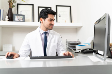 Handsome Doctor Working At Desk In Office