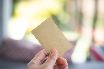 Gold card in hand on blur background.