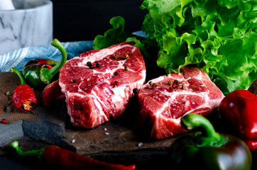 Meat concept. Meat steaks are ready to cook with vegetables lying on the table