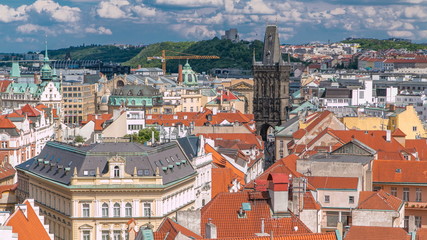 Fototapeta na wymiar Aerial view of the traditional red roofs of the city of Prague, Czech Republic with the Powder tower and Vitkov Hill in the distance timelapse.