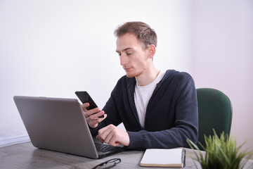 Portrait of young business man sitting at his desk desktop laptop technology in the office.Internet marketing, finance, business concept