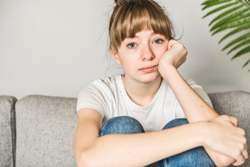 Naklejka premium Teen woman anxious worried woman sitting on couch at home.