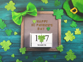 St Patrick Day greetings on letter board on dark green wooden rustic background with shamrocks and...