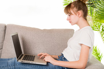 Naklejka premium Happy woman relaxing on cozy sofa with laptop in living room at home