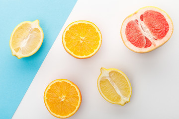 Top view of citrus halves on white and blue background
