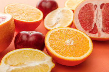 Selective focus of citrus halves and apples on colorful background