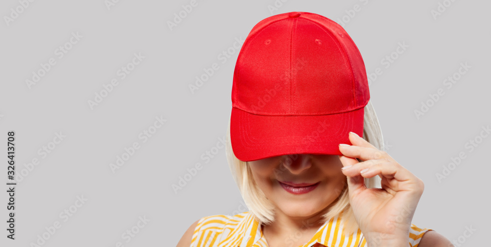 Wall mural Blank red baseball cap mockup template, wear on women head, isolated, clipping path. Woman in clear hat and t shirt mock up holding visor of caps. Cotton basebal cap mokcup on delivery guy.