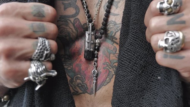 male hands open a heart-shaped tattoo on the chest