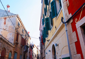 Fototapeta na wymiar Street with beautiful old buildings of different colours in Rovinj, Croatia