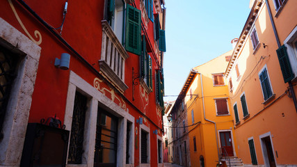 Street with beautiful old buildings of different colours in Rovinj, Croatia