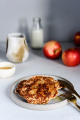 Homemade buckwheat apple pancakes with honey on light background. Pescajounes.  Hard light, deep shadow. Selective focus