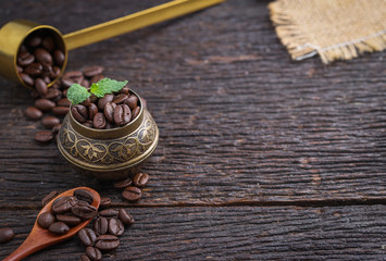 Ground coffee and a vintage brass grinder on wooden table.copy space
