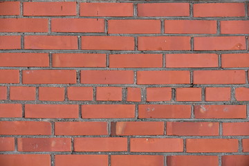 Old shabby, wrecked brick wall with grey cement mortar as background