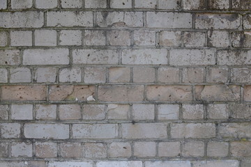 Old shabby, wrecked brick wall with grey cement mortar as background
