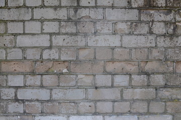 Old shabby, wrecked brick wall with grey cement mortar as background