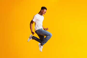 Fototapeta na wymiar Happy screaming young african american man jumping