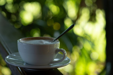 Morning cup of coffee and nature on green background .