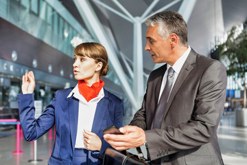 Passenger service agent assisting passenger to his gate in airport