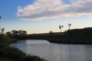 Windmills on the river at sunset