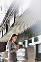 Fototapeta premium Portrait of young attractive businesswoman looking at her passport in airport