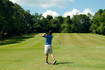 Blurred golfer playing golf in the evening golf course, on sun set evening time.