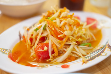 Close-up on Thai papaya salad on white plate