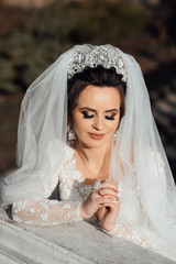 Portrait of beautiful bride posing in her wedding day. Portrait with natural light of young beautiful woman with stylish make-up and hairstyle looking down